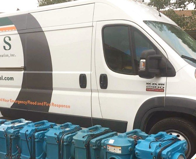 An ECOS van with a row of air scrubbers and dehumidifiers ready for a water damage job